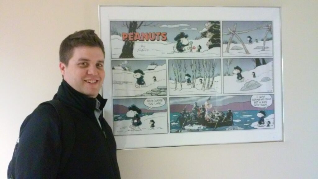 Matt standing in front of a Peanuts comic.